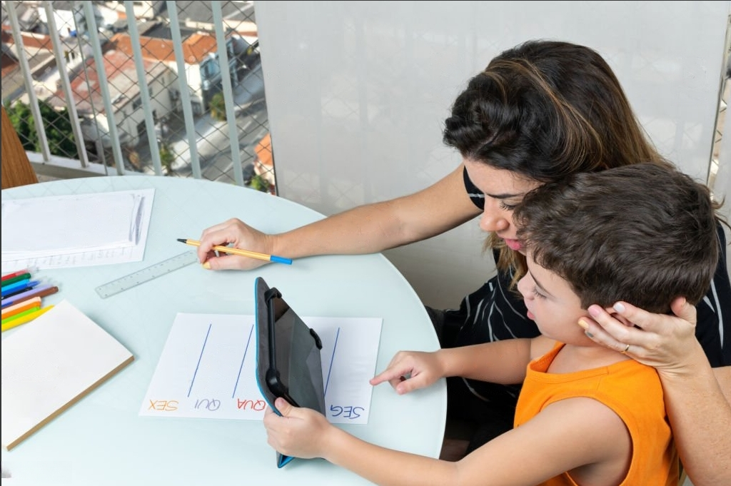 mother helping her son learn from online lecture on mobile