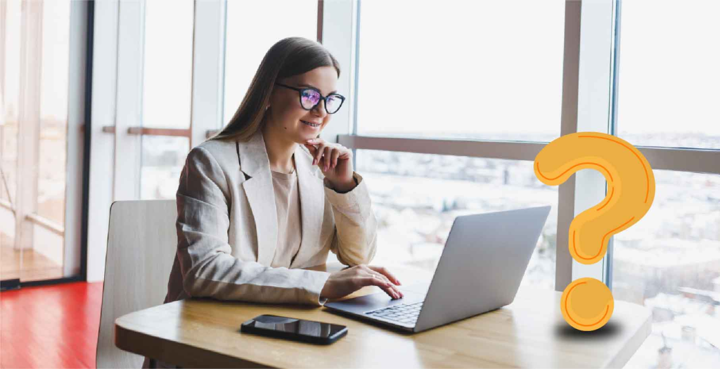 woman sitting in front of desk working on a laptop and thinking