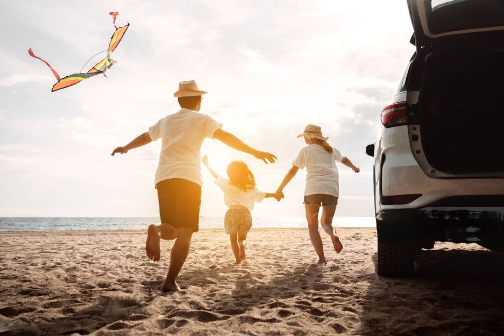 family celebrating car purchase on beach