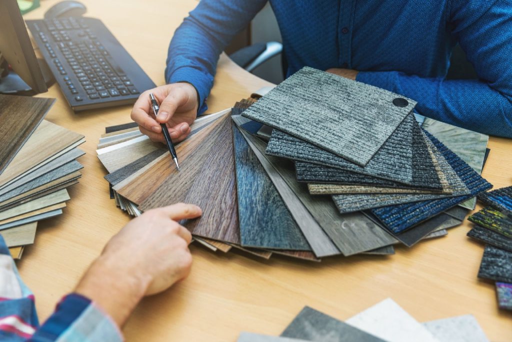 shopkeeper showing multiple carpet samles