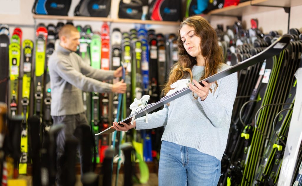 girl looking at ski in a ski shop