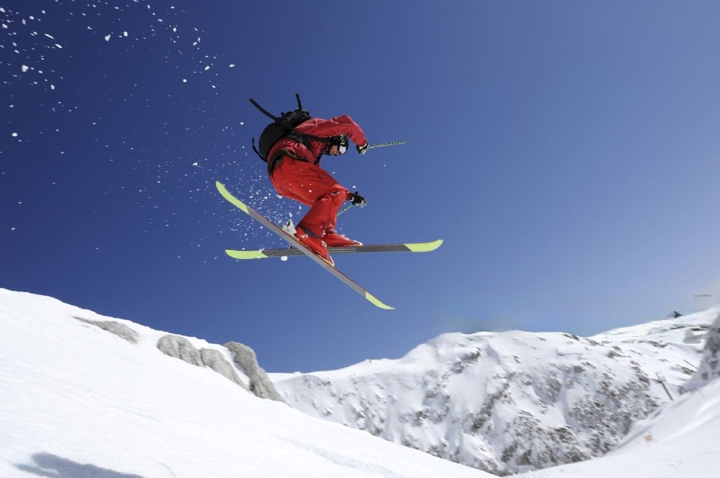 freestyle skier jumping against blue sky in background
