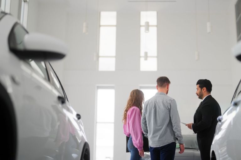 car dealer showing different options to a couple leasing a Car