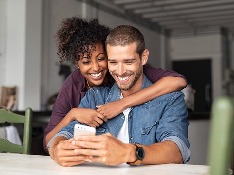 couple happily using smart phone
