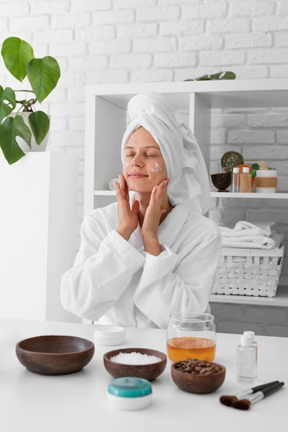 Medium shot woman using facial cream